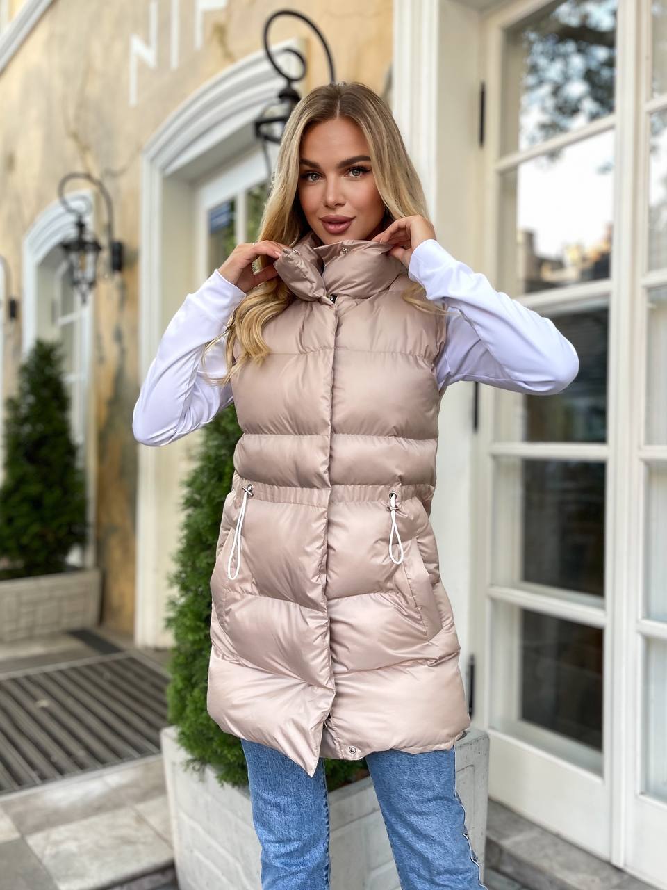 Подовжена жіноча демісезонна жилетка бежевого кольору 34843