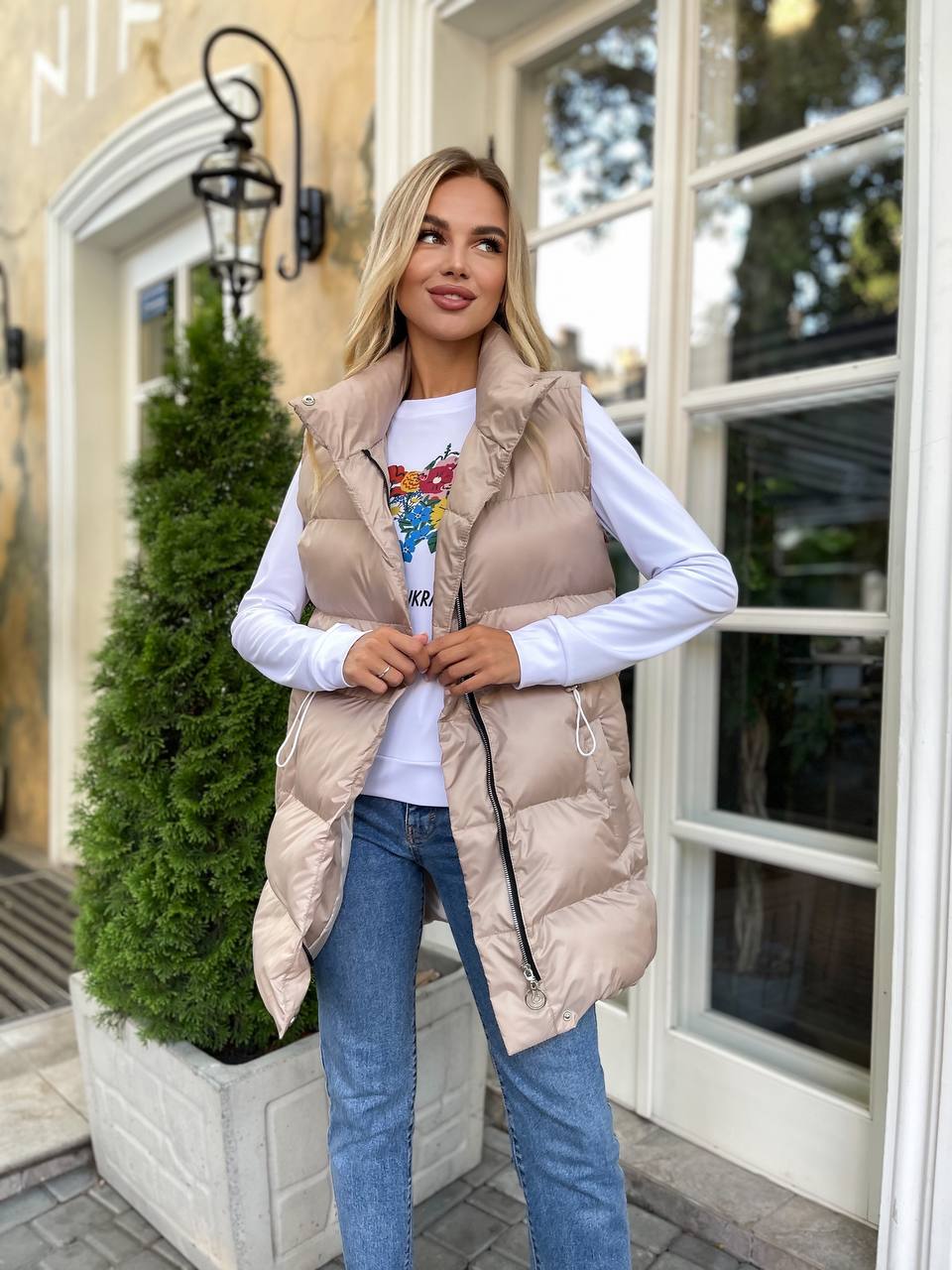 Подовжена жіноча демісезонна жилетка бежевого кольору 34843